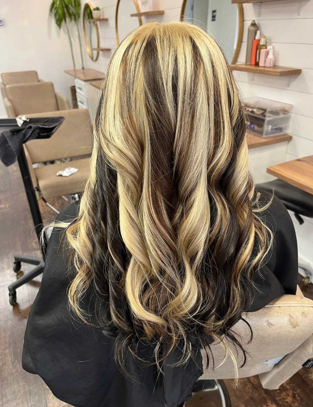 Blonde and black balayage hairstyle in a salon chair.